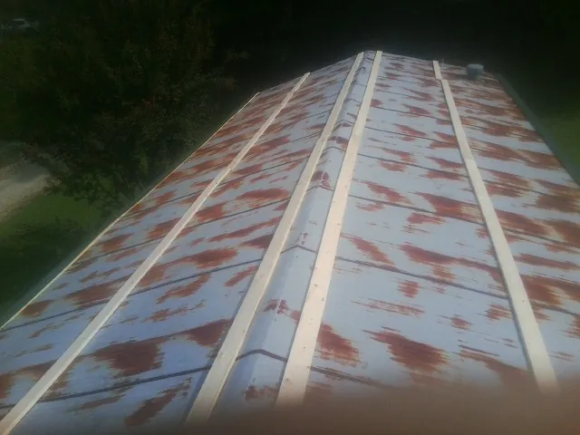 Rusted metal roof panels with new wood purlins before replacement — Storm Damage Roof Repair in Velma by Roofing Brothers
